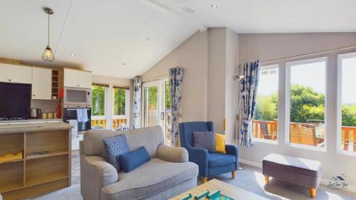 a living room with a couch and two chairs at Poppy An Immaculate Lake side Lodge the Perfect Retreat, Sleeps 4 in Ryde