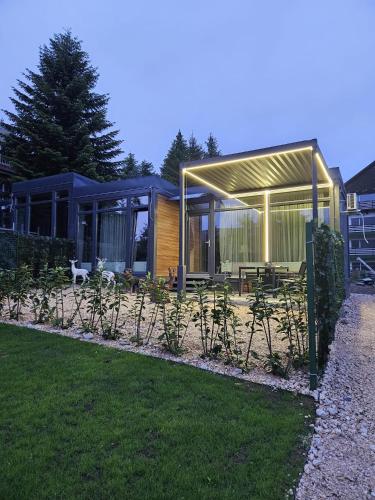 a house with a solarium in a garden at Diamond Resort Busteni in Buşteni