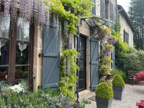 a house covered in wisteria and flowers at Le Moulin des Farges in Meymac