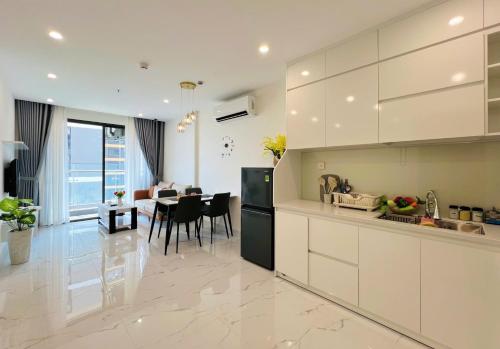 a kitchen with white cabinets and a dining room with a table at An Nhiên Homes 1PN View Đẹp Check-in Tự Do Gần Vincom Mega Mall1316 in Gò Công