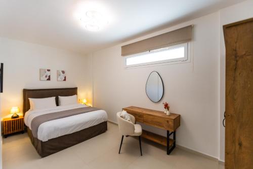 Un dormitorio con una cama, un escritorio y un espejo. en Villa Areka, en Gournes