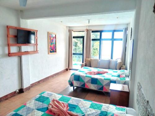 a living room with two beds and a couch at Hotel Porto Bello in San Pedro La Laguna