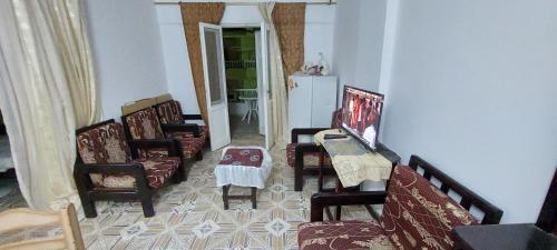 a living room with chairs and a table and a kitchen at قرية الخليج الكاسح in Marsa Matruh