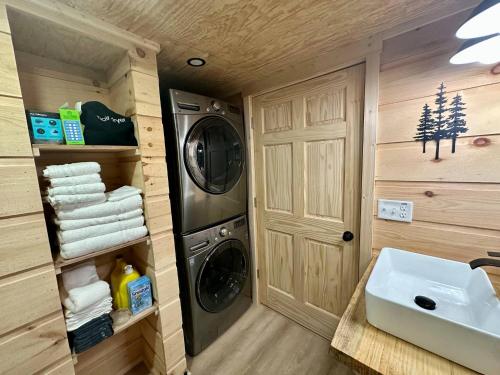a bathroom with a washer and dryer in a tiny house at Boulder Ridge Cabin in Eckerty