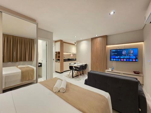 a hotel room with a bed and a television at Studio Novo no Centro para 4 pessoas in Foz do Iguaçu