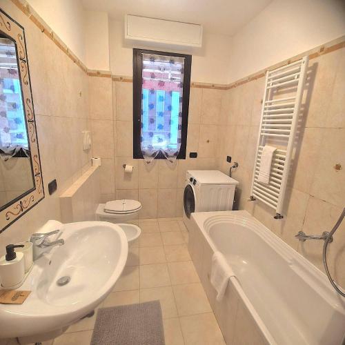 a bathroom with a sink and a tub and a toilet at Central Apartment Caniggia 1 with Terrace in Como in Como