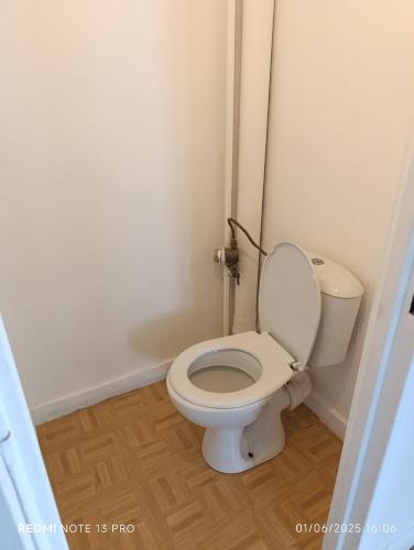 une salle de bain avec des toilettes blanches dans une chambre dans l'établissement Asnières-sur-Seine, à Asnières-sur-Seine