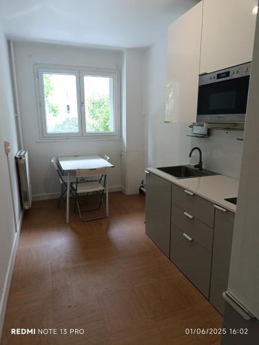 une petite cuisine avec une table et un évier dans l'établissement Asnières-sur-Seine, à Asnières-sur-Seine