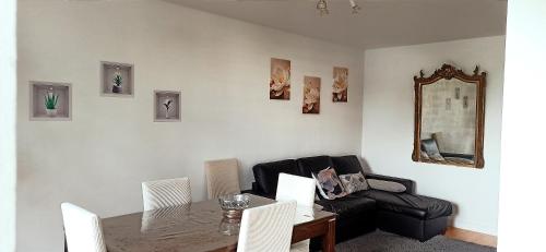 a living room with a table and a couch at Entre Ville & Nature-Sejour idéal a Massy in Massy