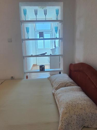 a bedroom with a bed and a window with glasses at Sky Apartments in Donji Štoj