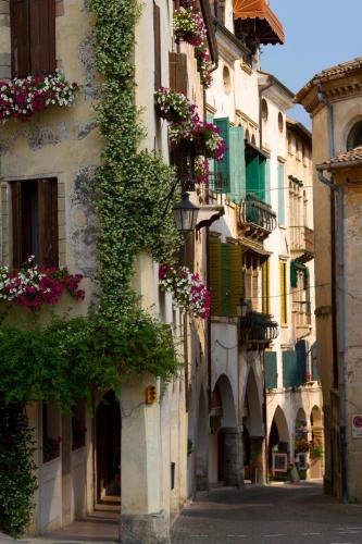 an alley with flowers on the side of a building at Appartamento al Sole in Paderno del Grappa