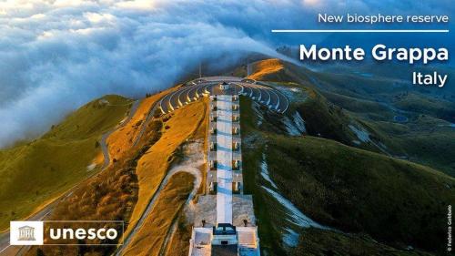 a bridge on top of a mountain in the clouds at Appartamento al Sole in Paderno del Grappa