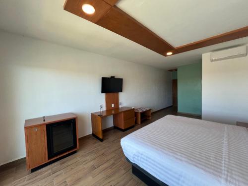 a hotel room with a bed and a tv at Hotel Mamá Dolores in Dolores Hidalgo