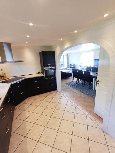 a kitchen and dining room with a table and chairs at Grand Lux House with private parking in Hjørring