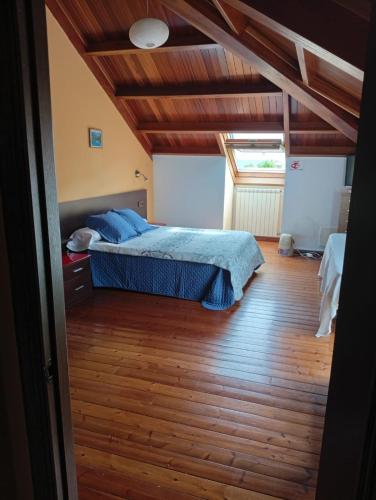 a bedroom with a bed and a wooden floor at Casa Buda Conors & Spa in Foz