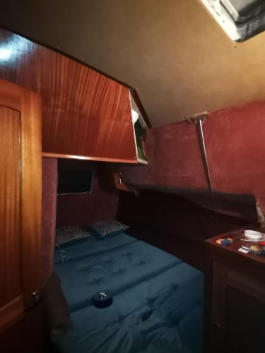 une petite chambre avec un lit et un bureau dans l'établissement Voilier de Collection, au Cap d'Agde