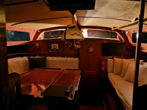 une table et un canapé à l'arrière d'un bateau dans l'établissement Voilier de Collection, au Cap d'Agde