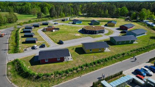an aerial view of a village with houses and cars at SKAN-PARK Ferienhäuser & Tiny Houses am Bärwalder See in Jahmen Ausbau