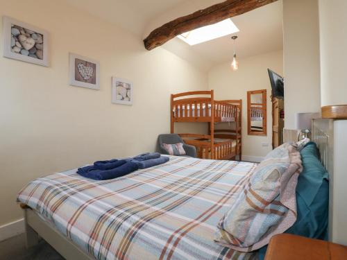 ein Schlafzimmer mit einem Bett, einem Stuhl und einem Kinderbett in der Unterkunft Milford Cottage in Belper