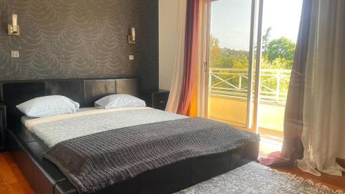 a bed in a room with a large window at Douro Villa in Porto