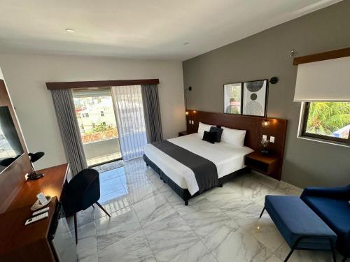 Un dormitorio con una cama, un escritorio y un sofá. en Pachamaya Executive Wellbeing, en Cancún