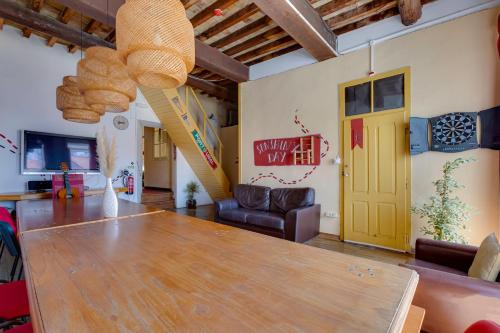 a dining room with a table and a yellow door at Suntrap Hostel in Lagos