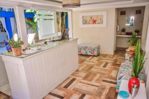 a large room with a counter and a wooden floor at Pousada Maresia Búzios in Búzios