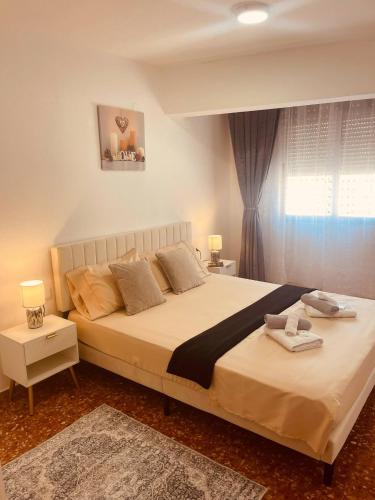 a bedroom with a large bed and a window at Cataleya Apartment in Cullera