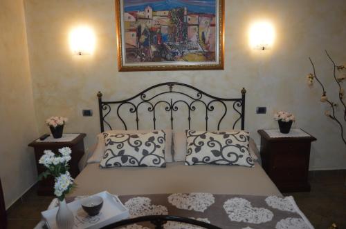 a bed with two pillows and a picture on the wall at Villa Tre Colli Agri B&B in Ariano Irpino