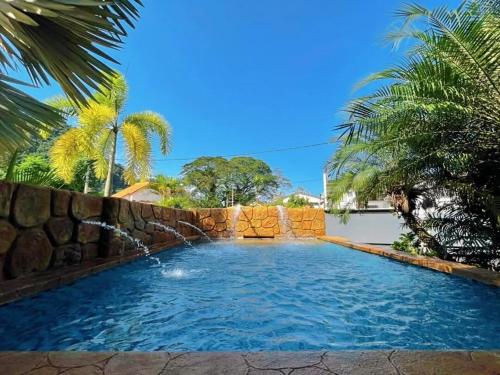 a swimming pool with a retaining wall and a fountain at Ipoh Tambun pool villa 5br 18pax bbq mahjong in Tambun