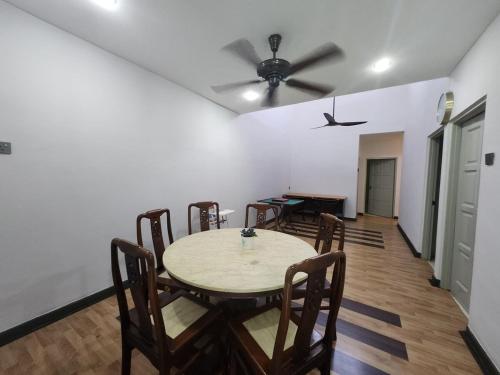 a dining room with a table and a ceiling fan at Ipoh Tambun pool villa 5br 18pax bbq mahjong in Tambun