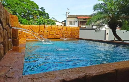 a swimming pool with a water fountain in a yard at Ipoh Tambun pool villa 5br 18pax bbq mahjong in Tambun