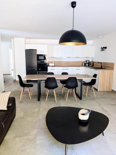 une cuisine et un salon avec une table et des chaises dans l'établissement Appartement tout confort à l'Ile-Rousse, à LʼÎle-Rousse