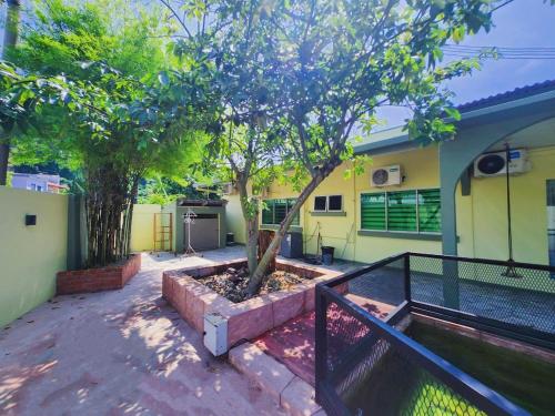 a tree in a planter in front of a house at Ipoh Tambun pool villa 5br 18pax bbq mahjong in Tambun