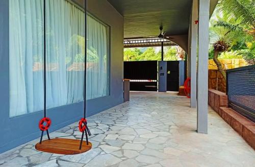 a porch with two swings on the side of a house at Ipoh Tambun pool villa 5br 18pax bbq mahjong in Tambun