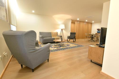 a living room with a couch and a chair at BUTEKO HOUSE AL in Miranda do Douro