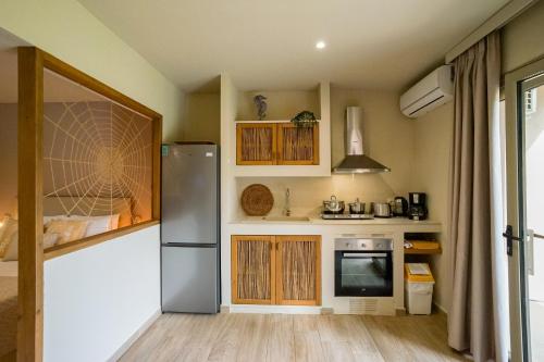 a kitchen with a stainless steel refrigerator and wooden cabinets at Forest Resort Suites Skiathos in Troulos