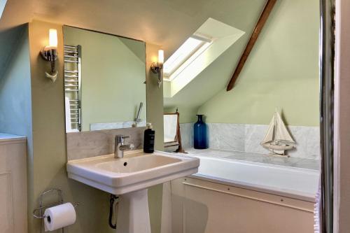 a bathroom with a sink and a tub and a mirror at Telegraph House by inspirestays-com in Chichester