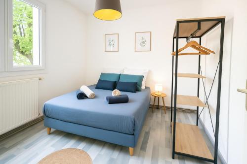a bedroom with a blue bed and a mirror at La parenthèse du sud Parking calme et confort in Valence