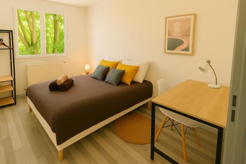 a small bedroom with a bed and a desk at La parenthèse du sud Parking calme et confort in Valence