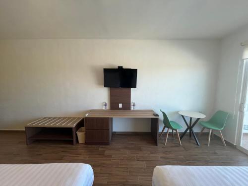 a room with a desk and a tv on a wall at Hotel Mamá Dolores in Dolores Hidalgo