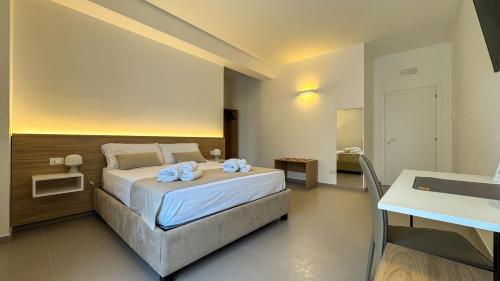 a bedroom with a bed with towels on it at Tevergad Premium Rooms in Terrasini