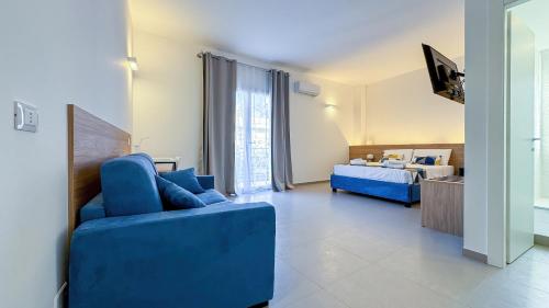 a living room with a blue couch and a bed at Tevergad Premium Rooms in Terrasini