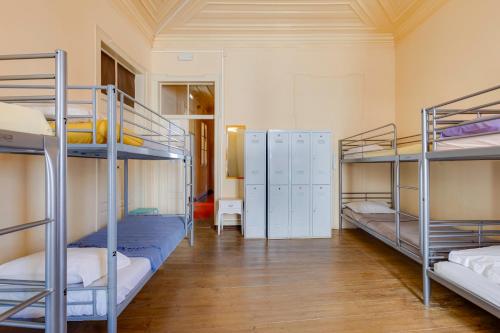 a room with three bunk beds and a hallway at Suntrap Hostel in Lagos