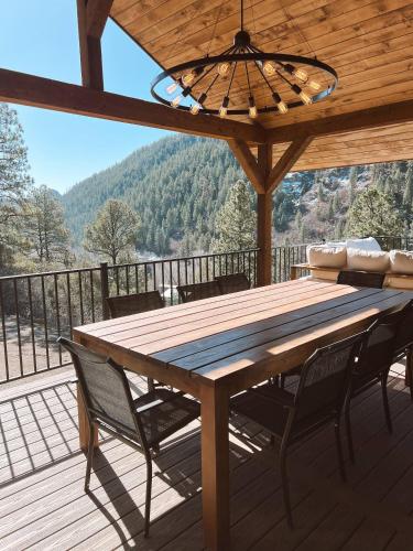 una mesa de madera y sillas en una terraza con vistas en Breathtaking View 12 Min to Downtown, en Durango
