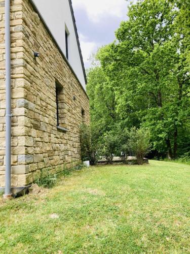 an old brick building with a grass yard at La Pacha, chambre d'hôtes in Spa