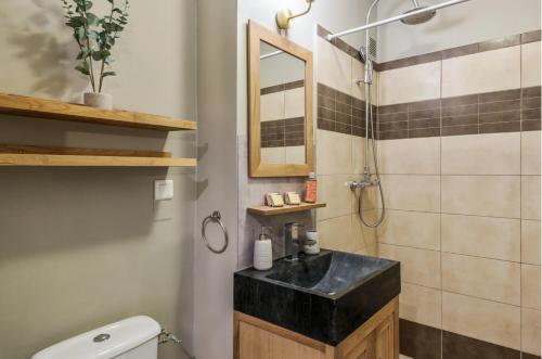 La salle de bains est pourvue d'un lavabo noir et d'une douche. dans l'établissement Au Petit Bois, à Chamonix-Mont-Blanc