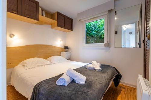 une chambre avec un grand lit avec des serviettes dessus dans l'établissement Beau mobile home avec terrasse, à Carnac