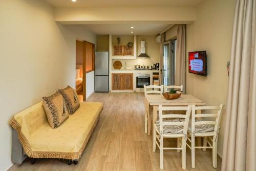 a living room and kitchen with a table and chairs at Forest Resort Suites Skiathos in Troulos