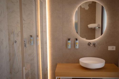a bathroom with a sink and a shower with a mirror at Palmar Boutique Hotel in Campofelice di Roccella